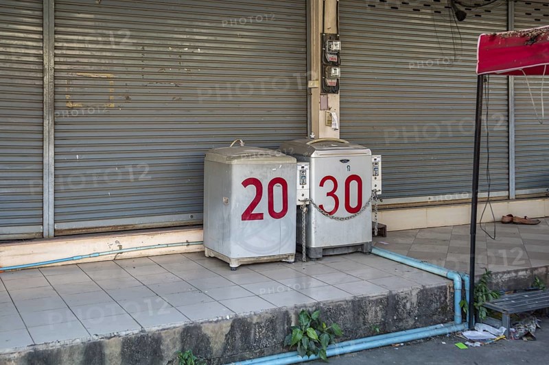Coin operated laundry washing machines on sidewalk in Chiang Rai province of Northern Thailand