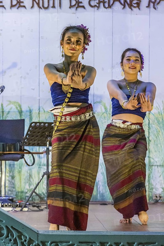 Traditional Thai dancers perform on a lighted stage at the night market in downtown Chiang Rai, Thailand