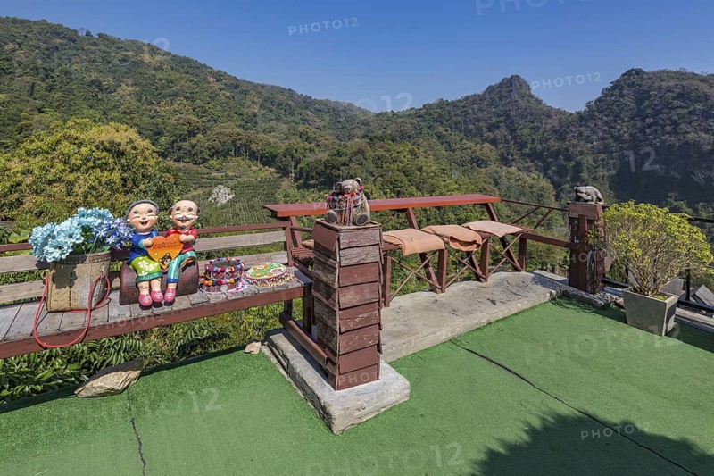 Ceramic statue of Thai couple holding a heart on a bench at the Doi Phamee coffee shop and restaurant in Mae Sai district of Chiang Rai, Thailand