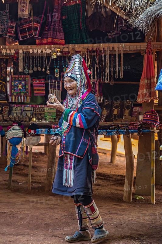 Elderly traditionally dressed woman selling art and craft items in the Akha tribe area of the Union of Hill Tribe Villages outside of Chiang Rai in the Nanglae District of Thailand