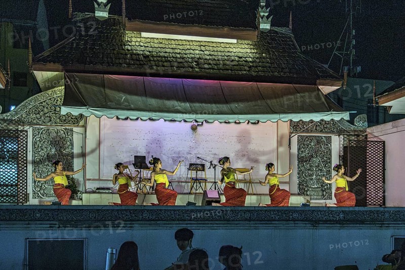 Traditional Thai dancers perform on a lighted stage at the night market in downtown Chiang Rai, Thailand