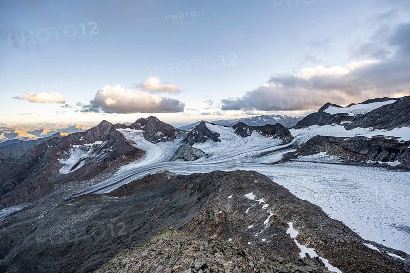 Sunset at the summit of the Becher, picturesque high mountain landscape, view of mountain peaks Königshofspitz and Schwarzwandspitz with glacier of the Übeltalferner, Stubai Alps, South Tyrol, Italy
