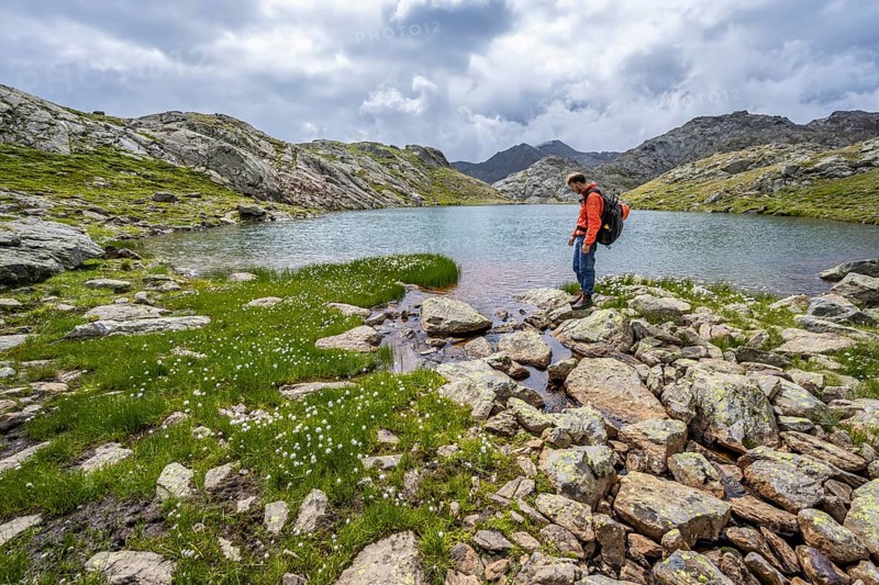Mountaineer at a mountain lake in high mountain landscape at the Upper Senner Egete, Seven Lakes Hike, Stubai Alps, near Ridnaun, South Tyrol, Italy