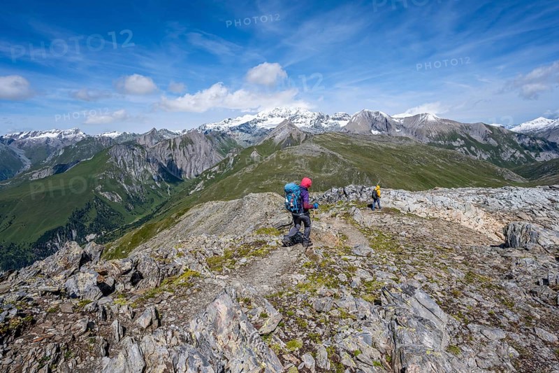 Mountaineers on a hiking trail, view of picturesque mountain landscape with snow-covered summit of the Großglockner, Vienna High Trail, Schober Group, Hohe Tauern National Park, Carinthia, Austria