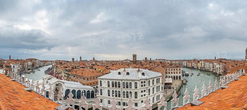 Stunning panoramic cityscape of venice, italy, showcasing the grand canal, traditional terracotta rooftops, and historic landmarks under a cloudy sky