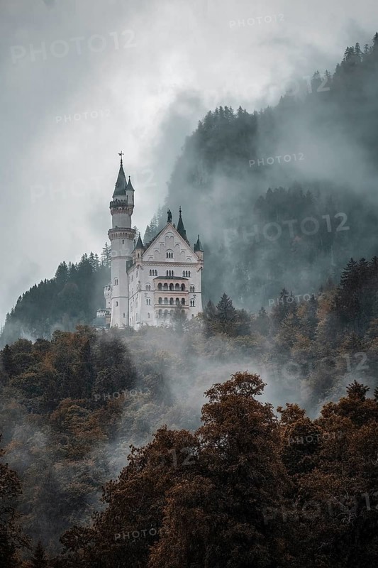 The mystical Neuschwanstein Castle in the dense fog of the mountains, Schwangau, Bavaria