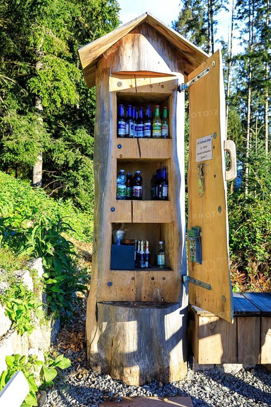 Tree trunk as a cupboard filled with drinks bottles at the Bollenbacher Bierbänkle, Haslach im Kinzigtal, Black Forest, Baden-Württemberg, Germany