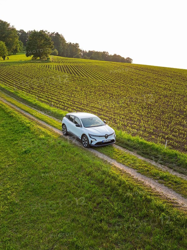 Small car drives on a green country road through a quiet village idyll, Renault Megane, Deer E Carsharing, electric car, Calw, Black Forest, Germany