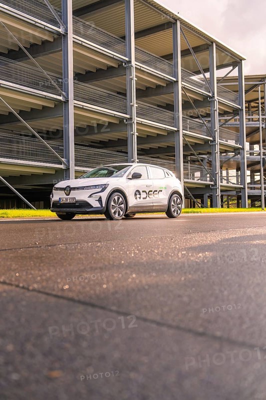 White Renault car in front of a multi-storey car park from a low perspective, Renault Megane, Deer E Carsharing, electric car, Calw, Black Forest, Germany