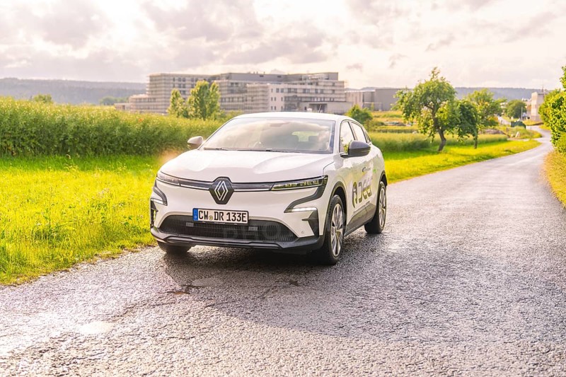 White Renault driving on a country road with the urban background, Renault Megane, Deer E Carsharing, electric car, Calw, Black Forest, Germany