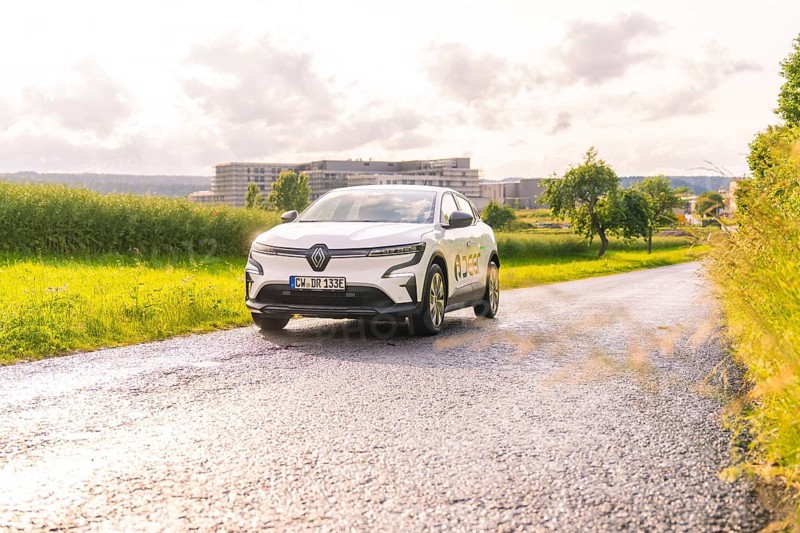 White Renault car driving along a tarmac road in a vast landscape, Renault Megane, Deer E Carsharing, electric car, Calw, Black Forest, Germany