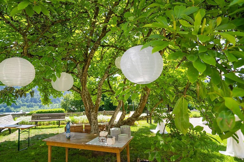Summer garden with table, crockery and decorative white lanterns under a tree, event and wedding location Kloster Lorch, Lorch, Germany