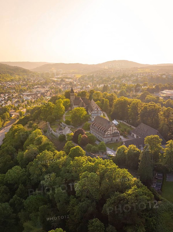 Aerial view of a historic castle surrounded by wooded hills at sunset, event and wedding location Lorch Monastery, Lorch, Germany