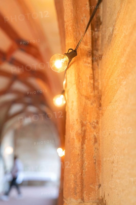Warm light from fairy lights in a historic stone archway, event and wedding location Lorch Monastery, Lorch, Germany