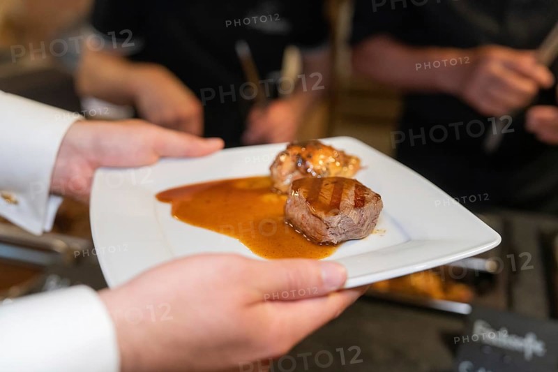 Delicious pieces of meat with sauce served on a white plate, Event and wedding location Lorch Monastery, Lorch, Germany