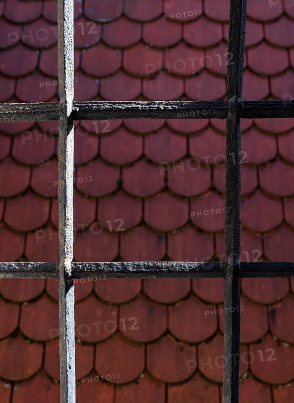 View through bars onto a red shingle roof, house roof, detail, Steyr, Upper Austria, Austria