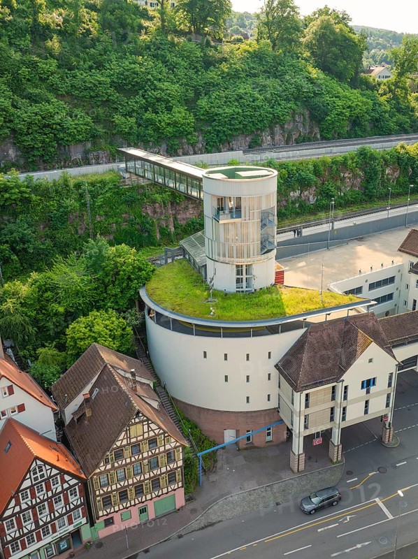Modern building with green roof next to historic half-timbered houses on a cliff, Calw, Black Forest, Germany