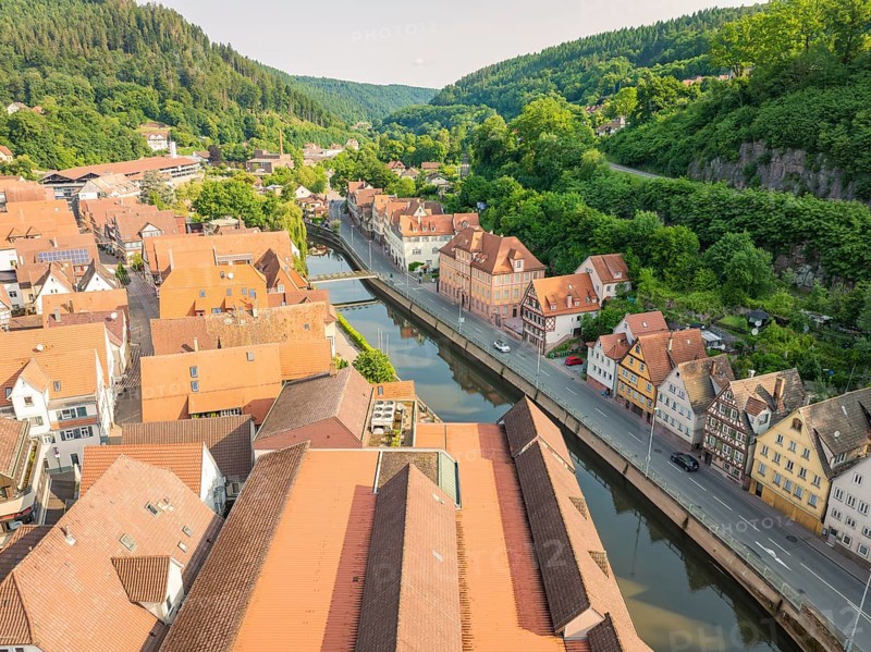 Town with red roofs on a winding river, embedded in forest hills, Calw, Black Forest, Germany