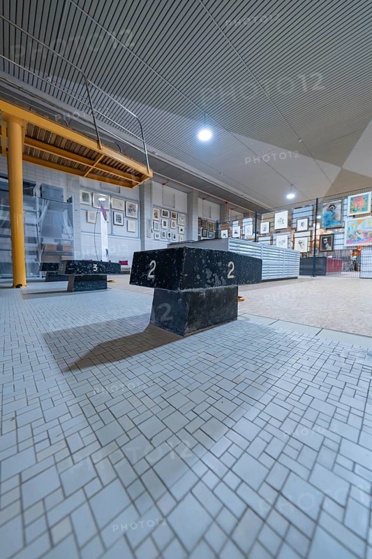 Numbered pedestal in an exhibition room with works of art in the background, historical art exhibition in the old swimming pool, Schaudepot, Calw, Black Forest, Germany