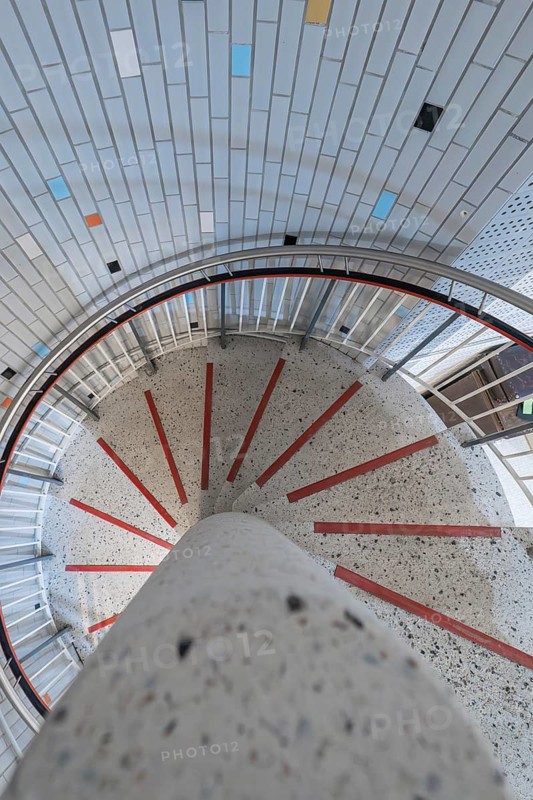 A spiral staircase with colourful tiles and a central concrete pillar, modern architectural design, historical art exhibition in the old swimming pool, show depot, Calw, Black Forest, Germany