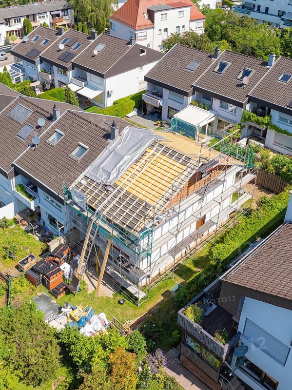 A house with scaffolding and partially new roof, surrounded by a green residential area, roof renovation, house construction, Pforzheim, Germany