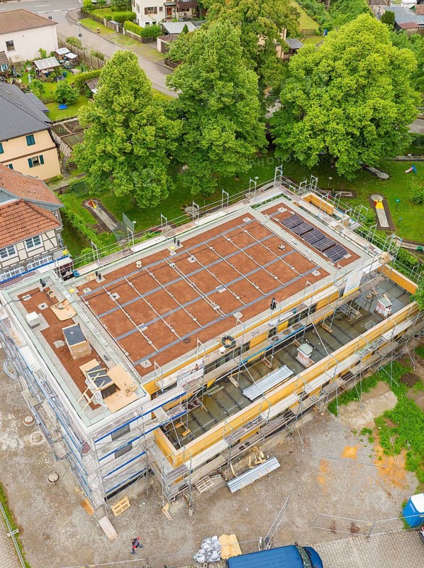 View of a building under construction, surrounded by extensive vegetation and construction site activity, Hirsau, Calw, Germany
