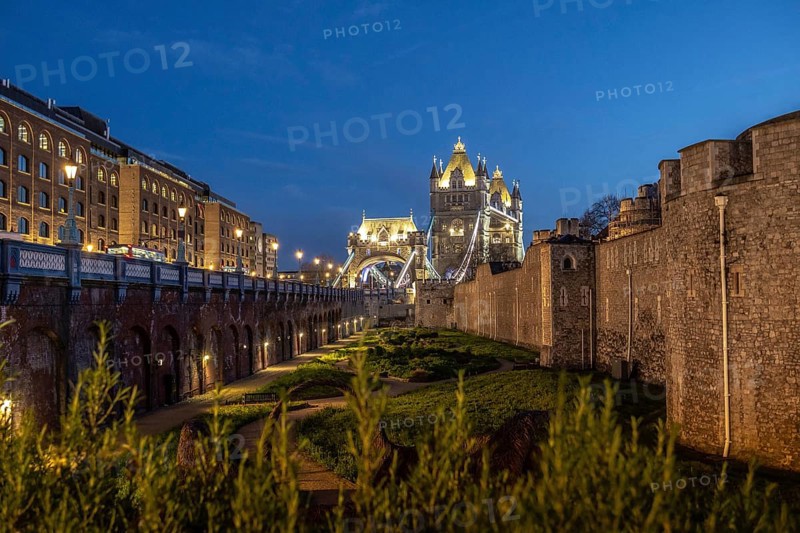 Tower bridge and the tower of london stand majestically illuminated against the twilight sky, showcasing london's historical landmarks