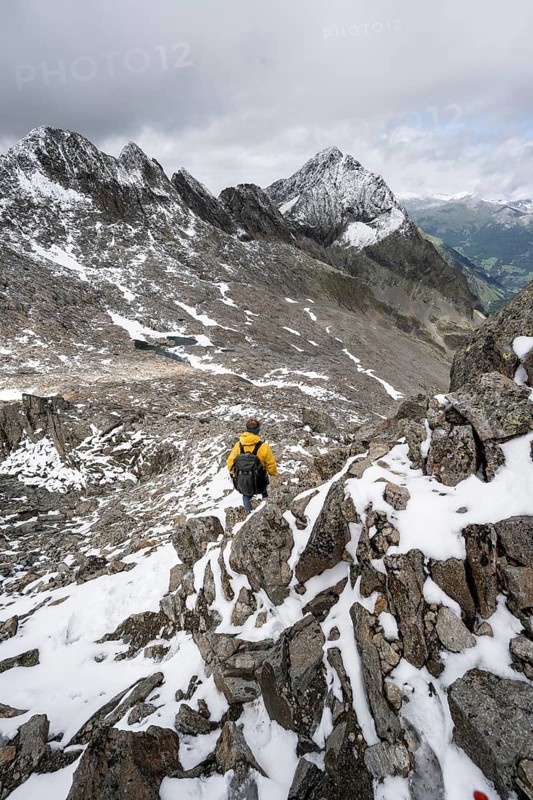 Mountaineer in rocky mountain landscape, at the summit of the Keeskopf, behind summit Kleiner Hornkopf, Schober group, Hohe Tauern National Park, Carinthia, Austria