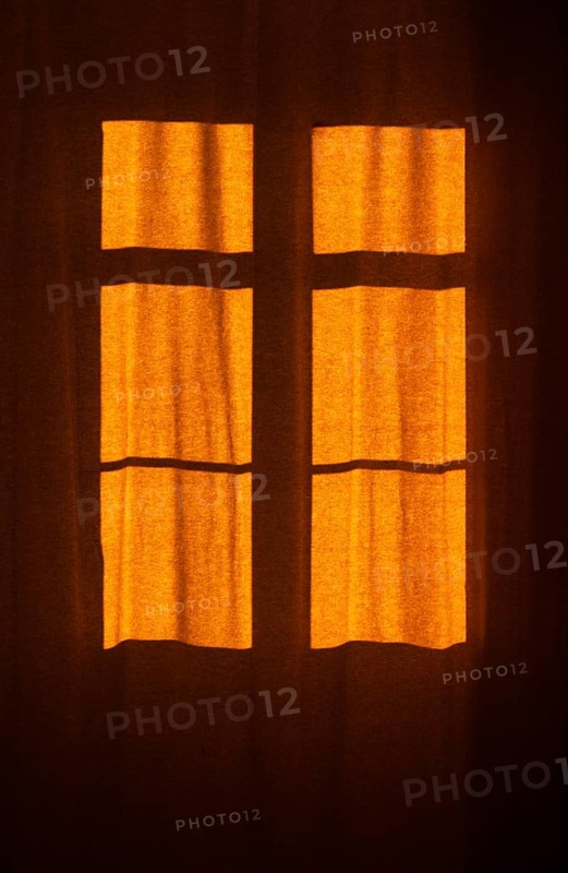 Interior view of a window with red curtain