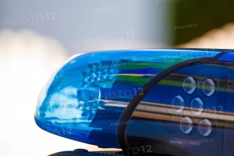 Symbolic image of a police operation: close-up of a flashing blue light on a police car