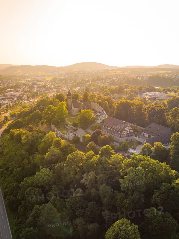 A village on a wooded hill with half-timbered houses and rural charm in the evening light, event and wedding location Lorch Monastery, Lorch, Germany
