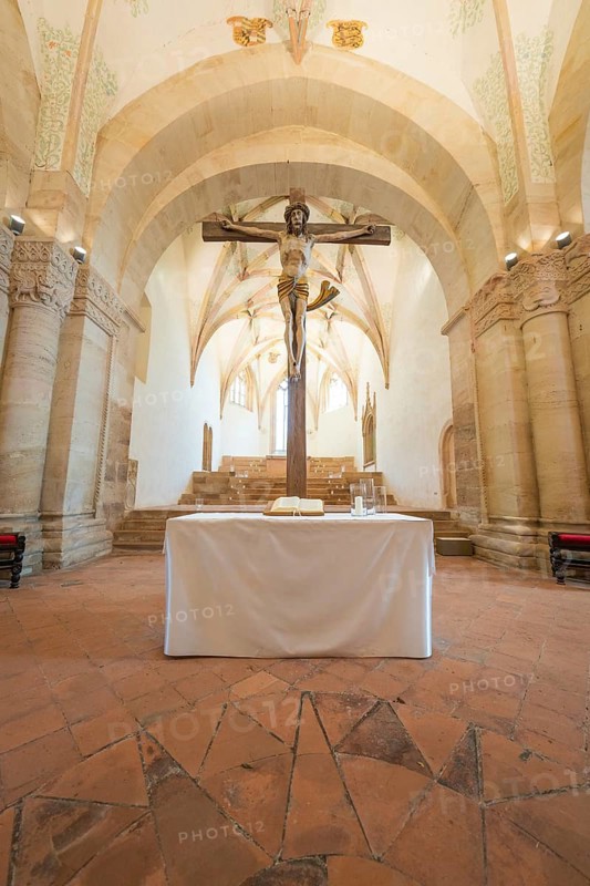 Altar with crucifix in a sacred room with stone arches, event and wedding location Lorch Monastery, Lorch, Germany