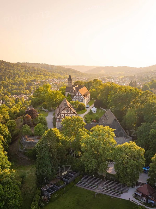 Aerial view of a village with a church surrounded by greenery at sunset, event and wedding location Lorch Monastery, Lorch, Germany