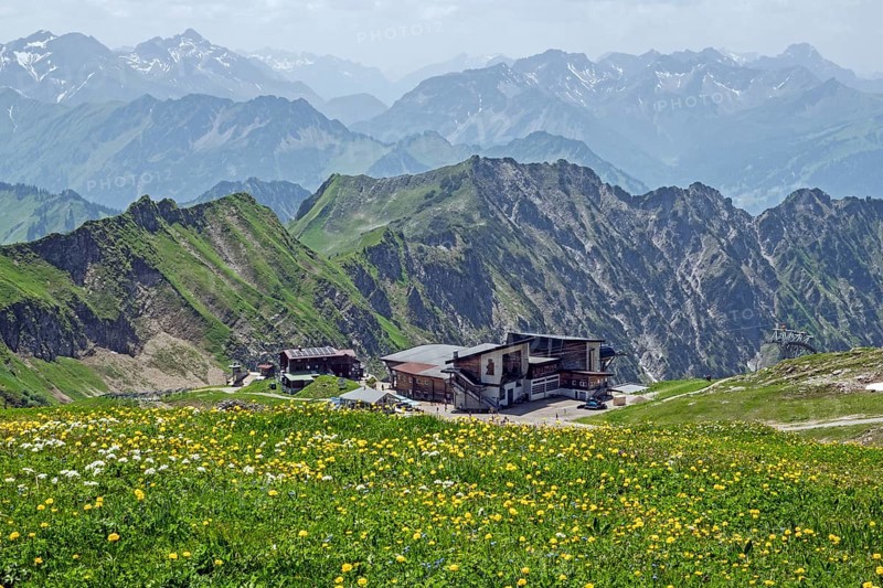 Edmund-Probst-Haus and Höfatsblick mountain station of the Nebelhornbahn, mountains of the Allgäu Alps in the background, yellow flowering meadow in the foreground, Oberstdorf, Oberallgäu, Bavaria, Germany