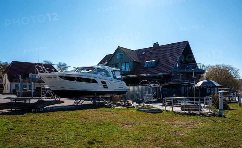 Motor yacht on a slag heap, Neuensiener See jetty in Seedorf, Rügen, Mecklenburg-Western Pomerania, Germany