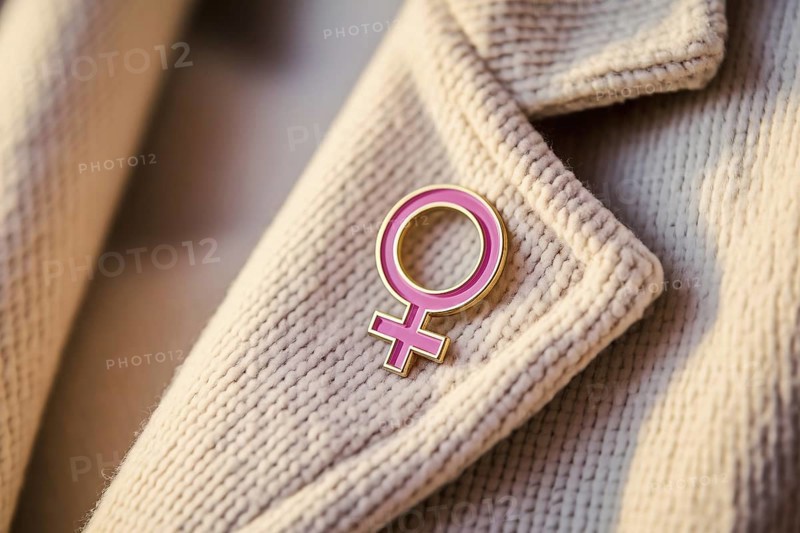 Pink female gender symbol pin attached to jacket, symbol of feminism and identity. Generative ai, AI generated