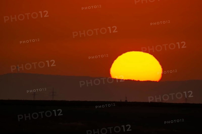 The sun rises behind the Winterstein (left) in the Wetterau, Frankfurt am Main, Hesse, Germany