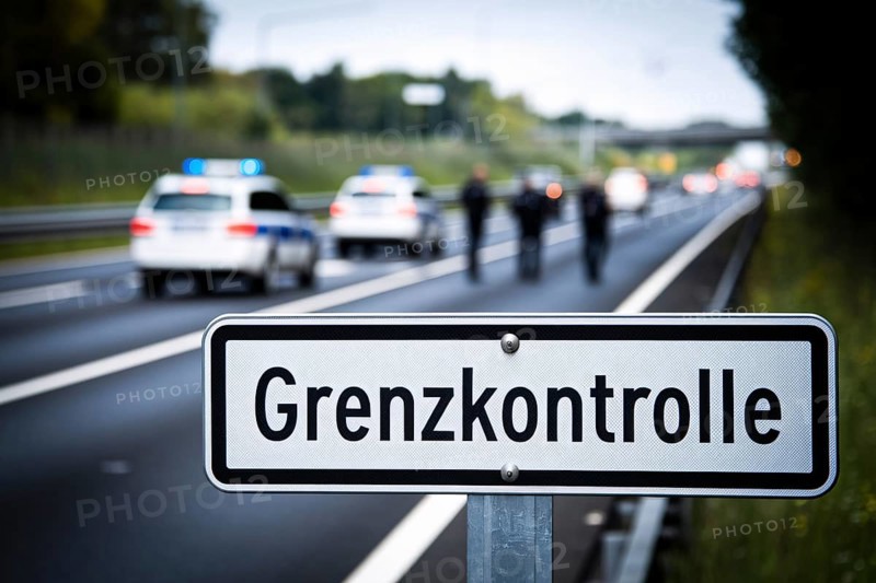 Close up of road sign saying 'Grenzkontrolle' (border control) with blurry police car and offecers in background. Generative AI, AI generated
