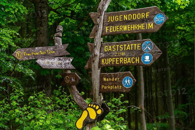Signpost with directions of the hiking trails, Frau Holle pond and car park, GEO nature park Park Frau Holle Land am Meissner, low mountain range, legendary figure, home of the fairy tale, information, district of Kassel, Fulda Werra Bergland, Germany