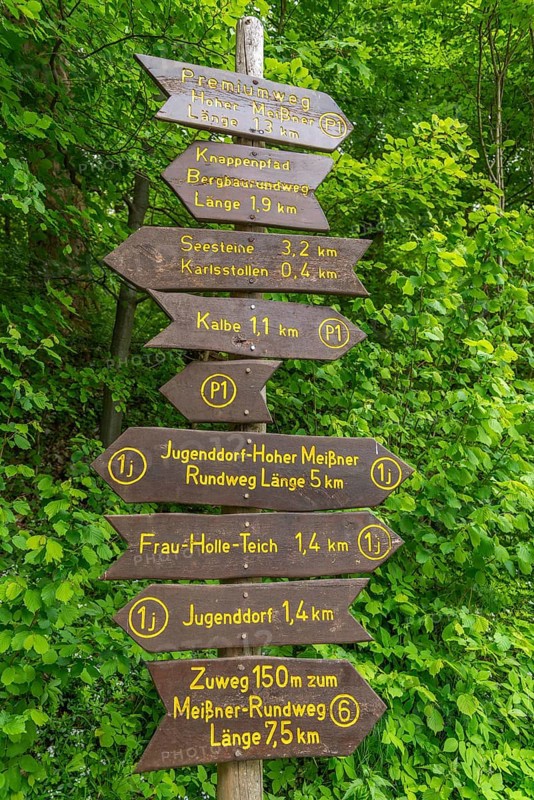 Signpost with directions for hiking trails and premium trails, GEO nature park Park Frau Holle Land am Meissner, low mountain range, legendary figure, home of the fairy tale, information, Kassel district, Fulda Werra Bergland, Germany