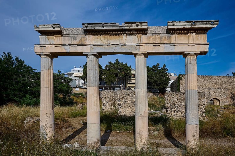 Ruins with three standing ancient columns and building remains in the background, Archaeological site, Xysto Columned Hall, Gymnasio, Western Excavation, Kos Town, Kos, Dodecanese, Greek Islands, Greece