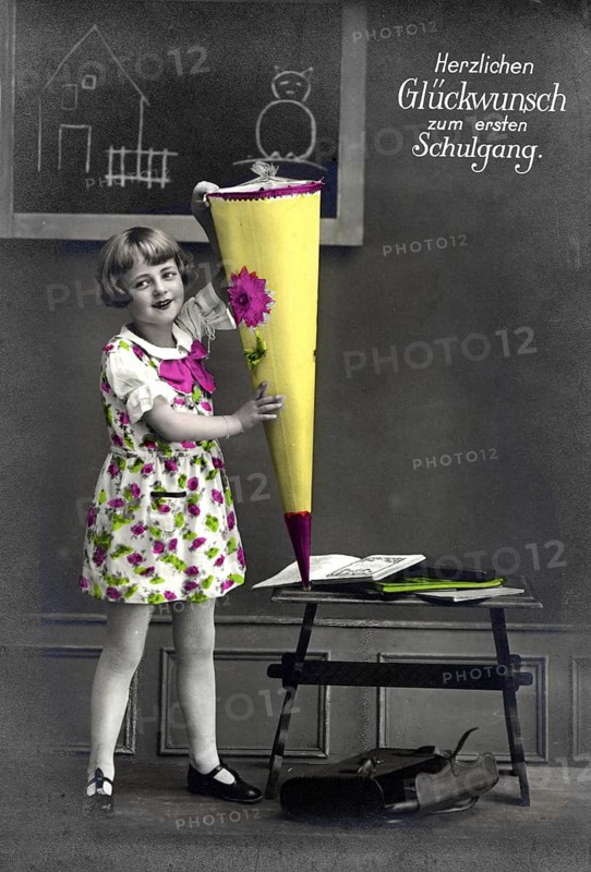 First day at school, 1930, Girl with colourful school bag in front of a blackboard, Historical photo