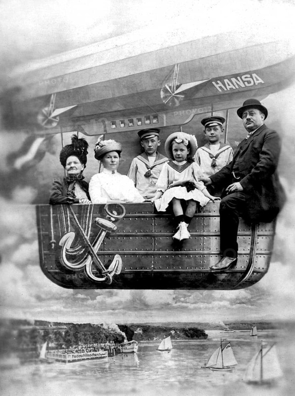 Family in balloon dummy, 1910s, A family sits in the gondola of an airship with the name Hansa over a river, historical photo
