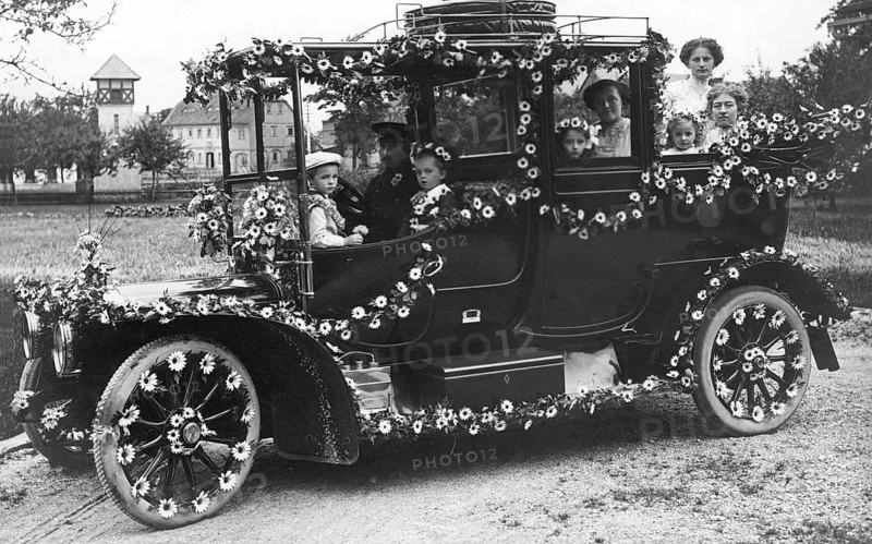 Wedding car with flowers, 1910s, A happy family sits outside in a vintage car decorated with flowers, Historical photo