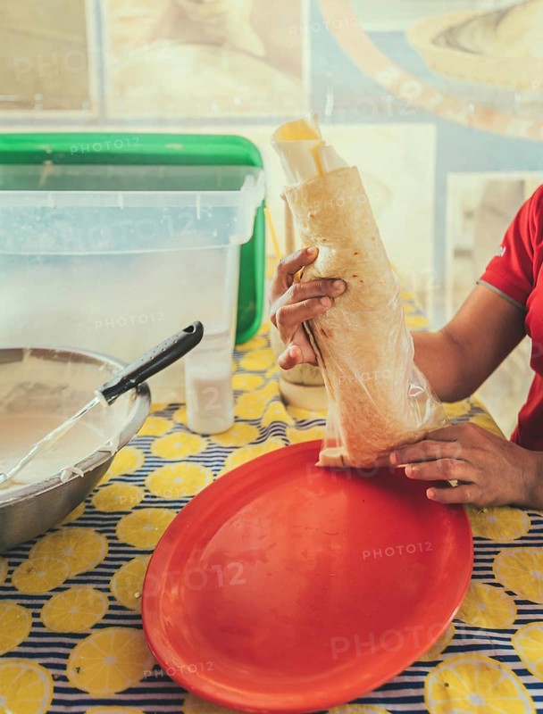 Vendor serving delicious quesillo in a bag. Hands of a person serving traditional quesillo