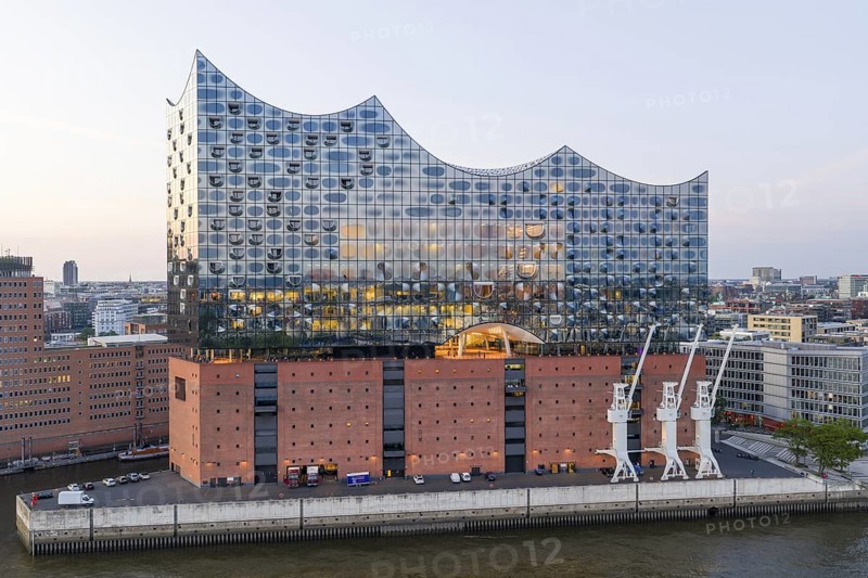 The Elbphilharmonie concert hall in Hamburg is reflected in the glass design above the historic Kaispeicher warehouse, Hamburg, Germany