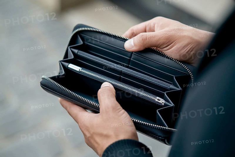 Hands holding empty black wallet. Concpet for financial struggle and economic hardship. Generative AI, AI generated
