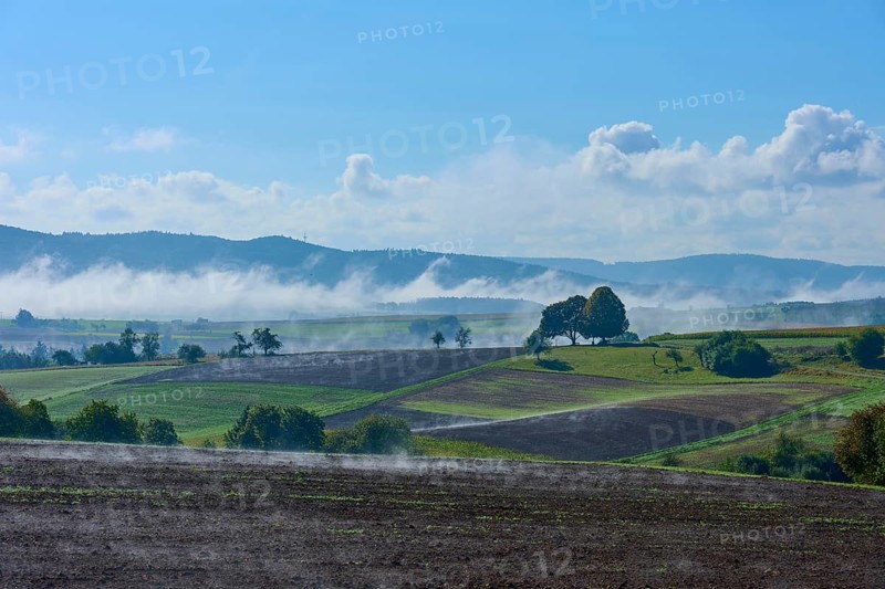 Picturesque fields with fog and blue sky in a hilly landscape, Schmachtenberg, Miltenberg, Spessart, Bavaria, Germany