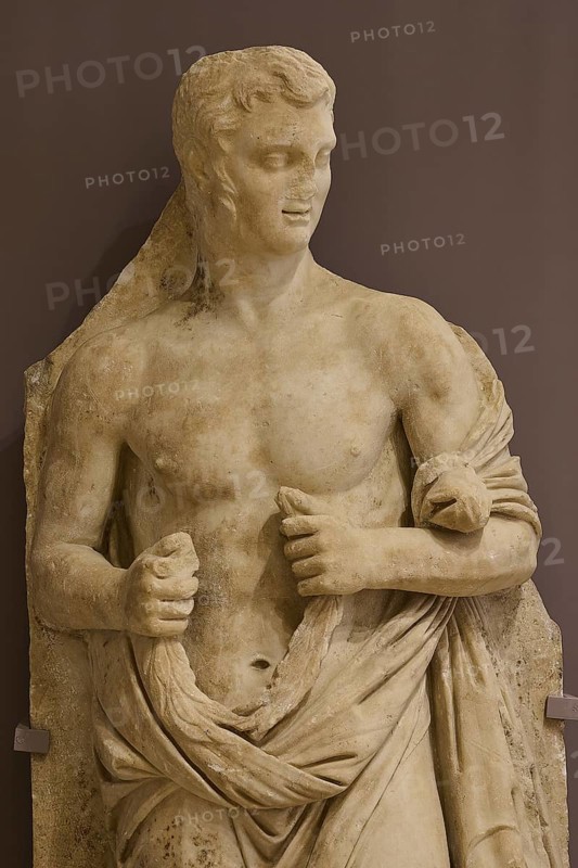Marble sculpture of a half-naked man, draped in a cloth, classically leaning, Archaeological Museum, Kos Town, Kos, Dodecanese, Greek Islands, Greece