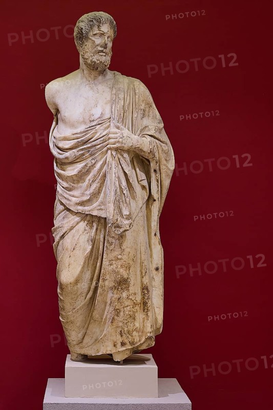 Marble statue of a bearded man in classical pose, surrounded by cloths, Archaeological Museum, Kos Town, Kos, Dodecanese, Greek Islands, Greece